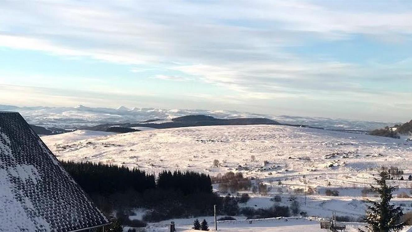 Chalet avec vue sur les monts du Cantal sous la neige à Super Besse